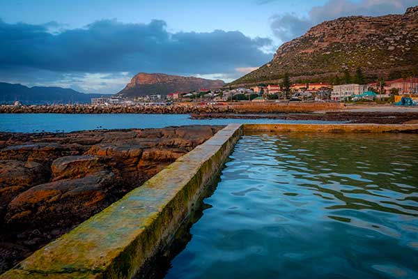Camps Bay Beach in Cape Town with palm trees, mountains and Atlantic Ocean