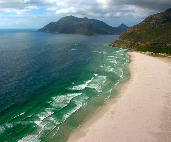 Wide empty stretch of Noordhoek Beach beneath the mountains near Cape Town