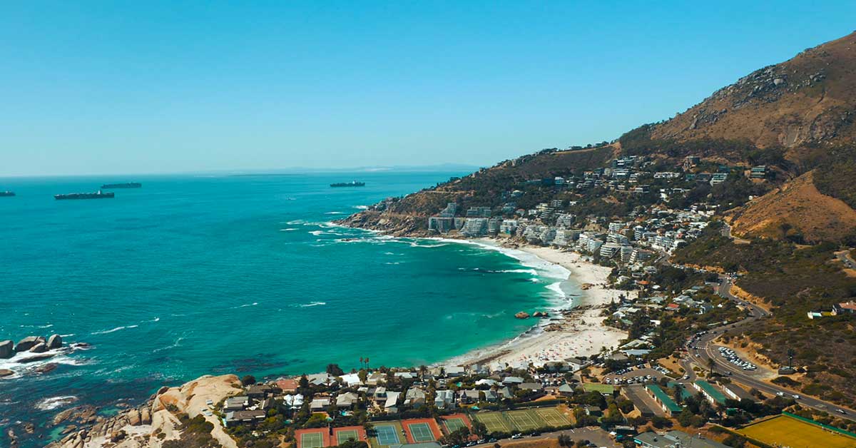Cape Town coastline with a sandy beach, turquoise Atlantic Ocean and mountains in the background