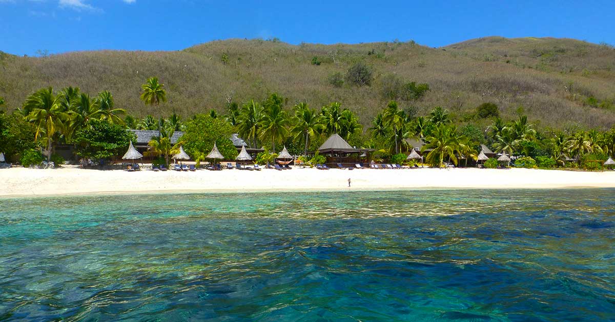 Tropical white sand beach surrounded by turquoise water in the Mamanuca Islands, Fiji