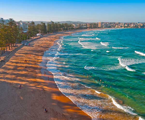 Manly ferry arriving near Sydney Harbour with beach and coastline