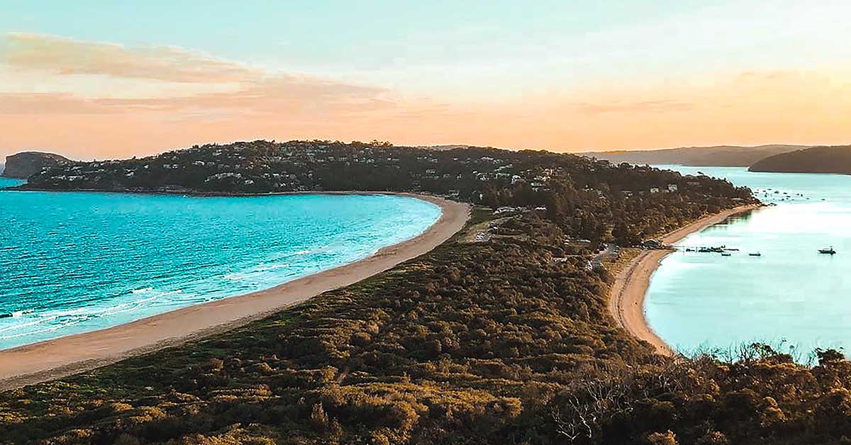 Sydney beach coastline with golden sand, blue ocean and city skyline